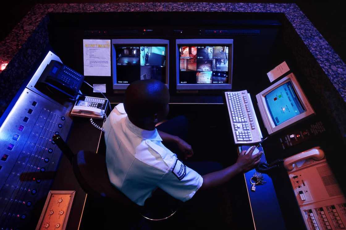 A security guard at a monitoring station A security guard at a monitoring station